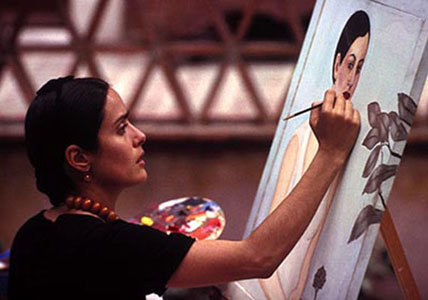 Film still from Hollywood movie Frida: Salma Hayek miming Frida Kahlo painting a portrait